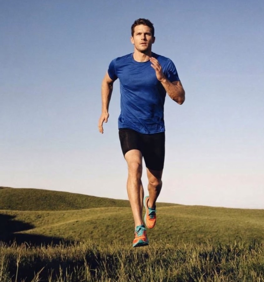 Un homme court sur une colline, en tee-shirt bleu