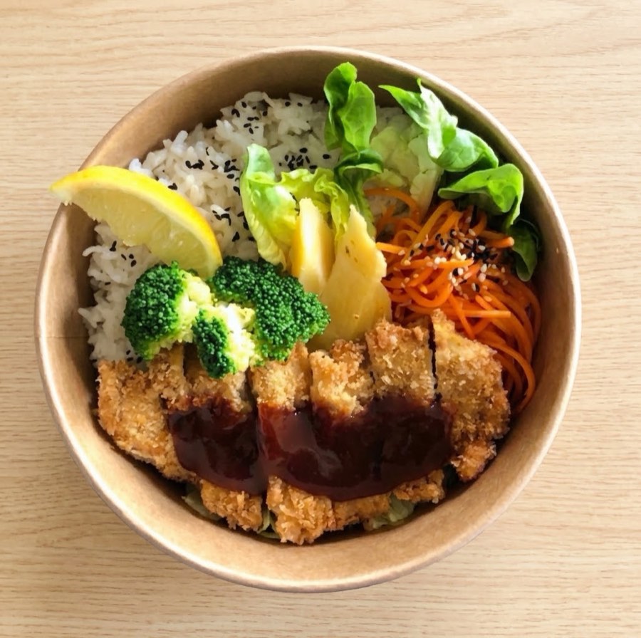Un bowl au chicken katsu : poulet pané en tranches avec sauce tonkatsu, riz, brocoli, carotte râpée, laitue et ananas