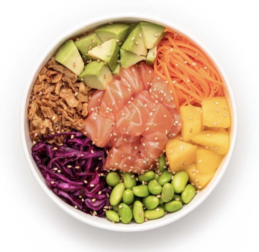 Un poke bowl vu de dessus : saumon cru, avocat, mangue, carotte, chou rouge, edamame et oignons frits sur du riz